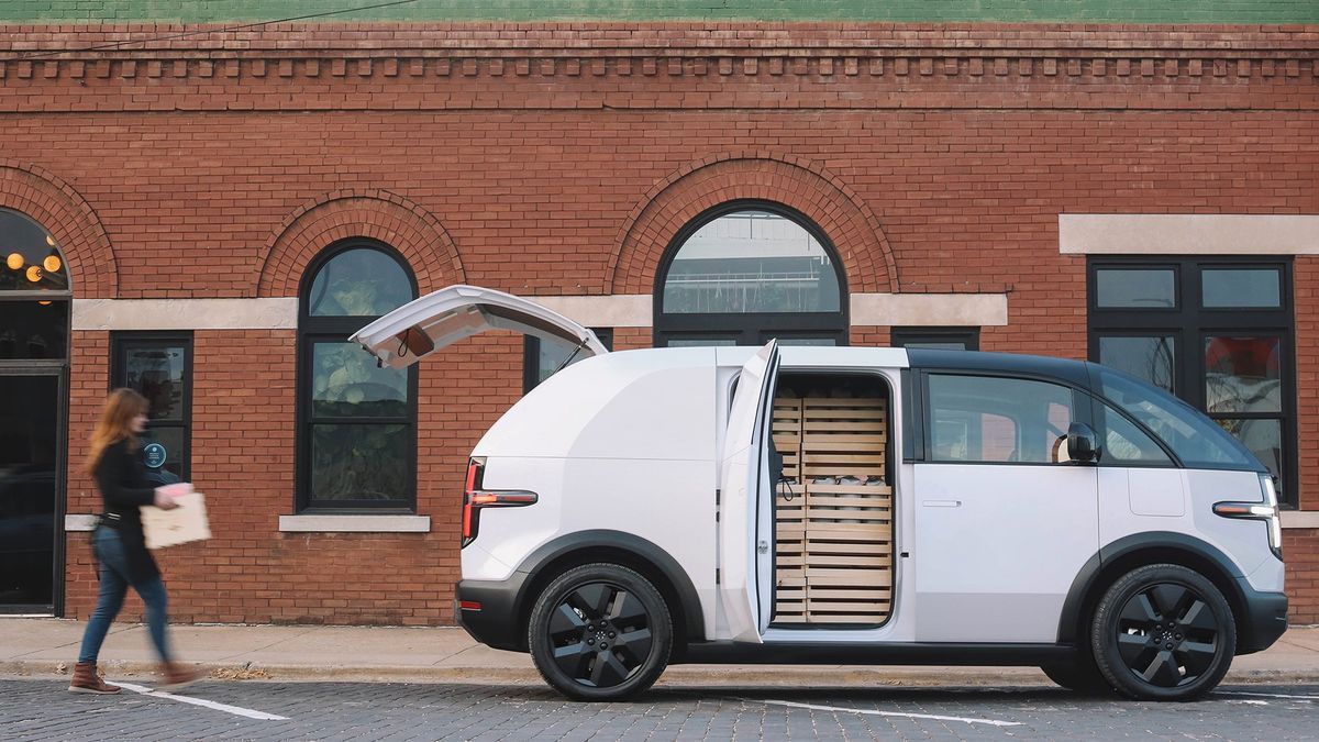 A woman loads a Canoo delivery EV.