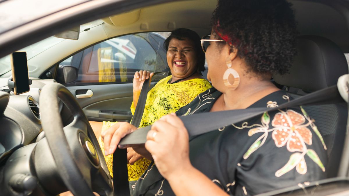 Two people put on front seat belts.