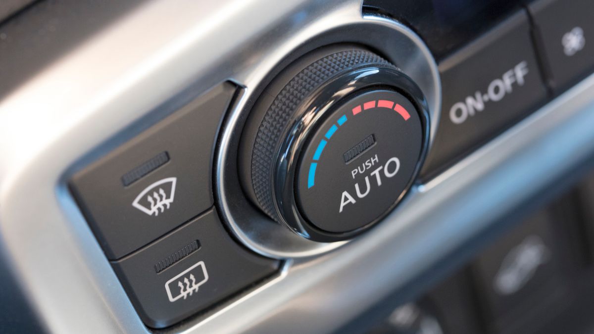 Close up view of a black car air conditioner control unit, with blue marks on the left side for cold and red marks on the right side for hot.